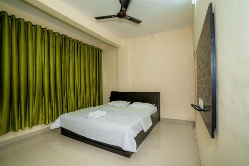 een slaapkamer met een bed en een groen raam bij Paradise Homestay in Pune