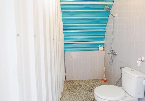 Rainbow Glamping في Padangan: حمام مع مرحاض وستارة دش جرداء زرقاء