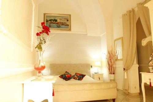 un soggiorno con letto e vaso con fiori di Stella Marina a Porto Cesareo