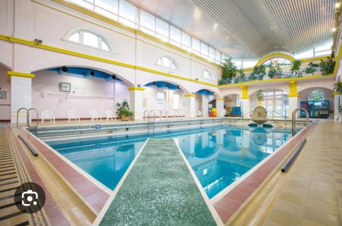 une grande piscine intérieure d'eau bleue dans l'établissement Appartement, à Sainte-Marie-aux-Mines