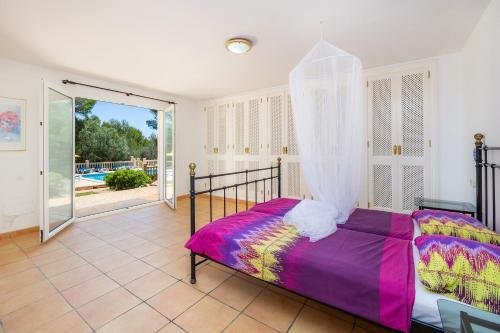 een slaapkamer met een bed en een glazen schuifdeur bij Villa Ensueño in Cala Ratjada