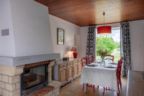 a dining room with a table and a fireplace at Gite de la Bouliniere in Challans