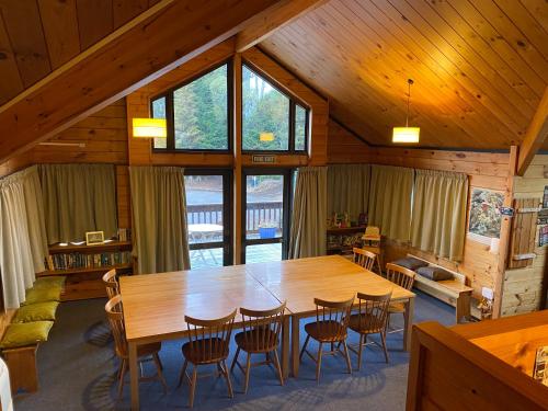 uma sala de jantar com uma grande mesa de madeira e cadeiras em Dakune Chill - The Lodge em Ohakune