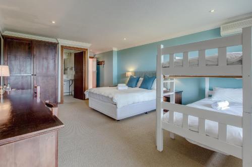 a bedroom with two bunk beds and a bathroom at Garden Route Ilita Lodge in Groot Brak Rivier