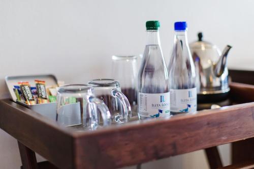 a wooden shelf with bottles and glasses on it at Garden Route Ilita Lodge in Groot Brak Rivier