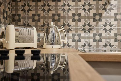 a kitchen counter with a toaster and a tea kettle at Nook Cottage in Richmond