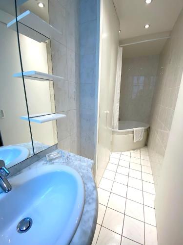 une salle de bain avec un lavabo et une baignoire dans l'établissement L'appartement Picquet, à Paris