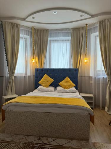 a bedroom with a blue bed with yellow pillows at Klass in Taraz