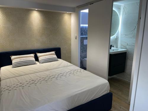 a bedroom with a bed and a bathroom with a sink at Bali 83 in Bandol