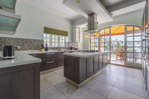 a large kitchen with wooden cabinets and a large window at Azure Dream: Lux 4-Bed Villa with Pool, Sea View & Garage in Mellieħa