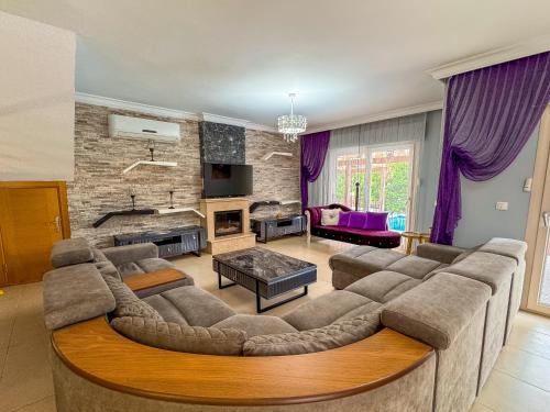 a living room with a large couch and a table at Villa Siesta Kusadasi in Kuşadası