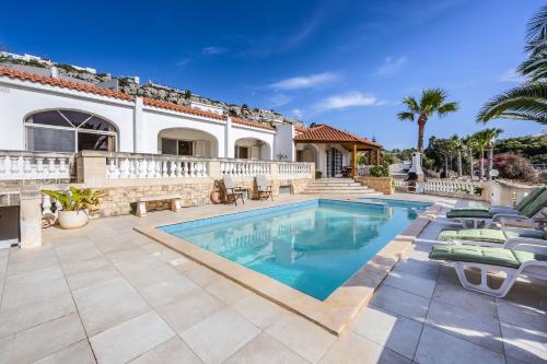 a swimming pool in front of a house at Azure Dream: Lux 4-Bed Villa with Pool, Sea View & Garage in Mellieħa