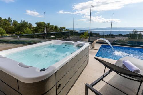 a jacuzzi tub on a patio with a pool at Luxury Villa Sirius, Bast, Makarska Rivijera in Bast