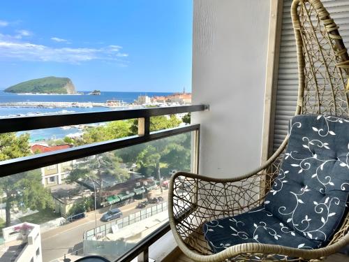 a chair on a balcony with a view of the ocean at Blue Marlin Apartments in Budva