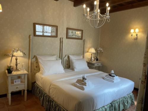 a bedroom with a large white bed with a chandelier at The Manor House in Laguardia