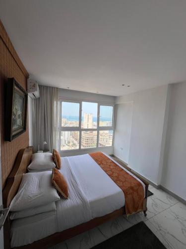 Sea View Paradise في الإسكندرية: غرفة نوم بسرير كبير مع نافذة كبيرة