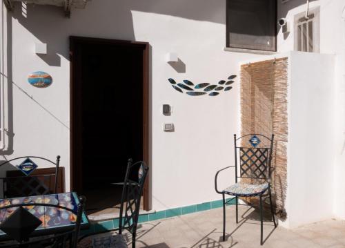 una habitación con 2 sillas y una puerta en Cala Di Luna House, en Vietri