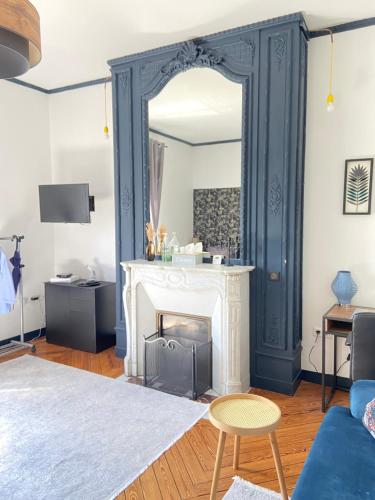 un salon avec une cheminée et un miroir dans l'établissement Le manoir des rêves, bulle de confort et de sérénité, proche clinique d'Europe, Parking privé gratuit, à Rouen