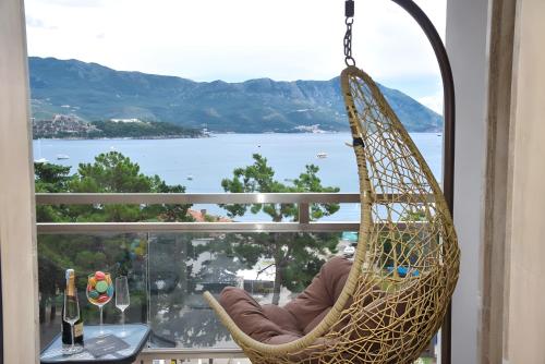 a hammock hanging from a window with a view of the water at Blue Marlin Apartments in Budva