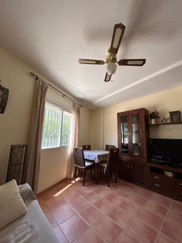 sala de estar con mesa y ventilador de techo en Apartamento Casa Rafa en Navajas