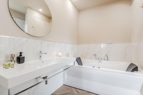a white bathroom with a sink and a mirror at La Villa in Tivoli