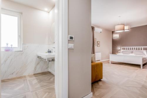 a white bathroom with a sink and a bed at La Villa in Tivoli