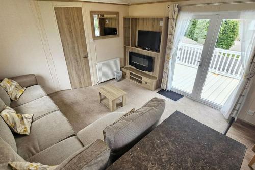 a living room with a couch and a tv at 2 bed 2 ensuite Holiday Home in St Austell