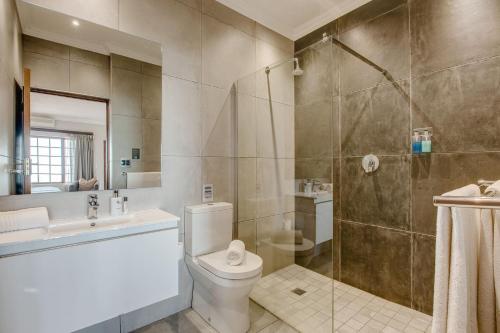 a bathroom with a toilet and a sink and a shower at Garden Route Ilita Lodge in Groot Brak Rivier