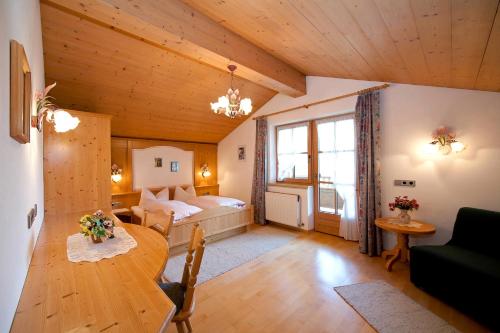 un soggiorno con un letto e un tavolo di Hauser's Ferienhof a Hart im Zillertal