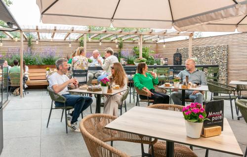 un grupo de personas sentadas en mesas en un restaurante en De Maasparel Nextdoor Suites en Arcen