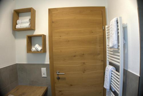 La salle de bains est pourvue d'une porte en bois. dans l'établissement Ferienwohnung Gartner, à Uderns