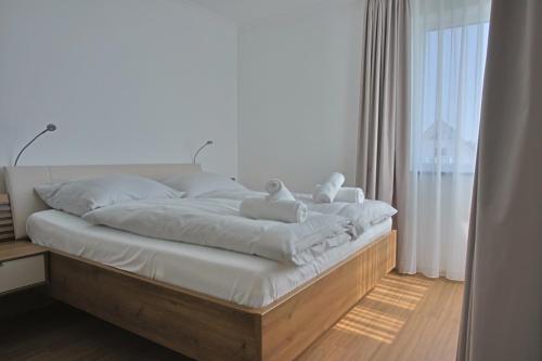 a bed with white sheets and pillows in a bedroom at Villa Baltic Star in Börgerende-Rethwisch
