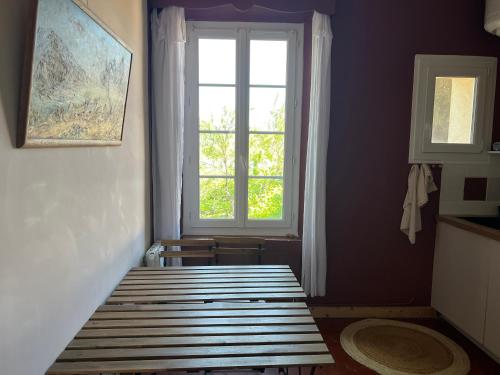 une chambre avec un banc devant une fenêtre dans l'établissement Charmant appartement pour 3 personnes près plage, à Hyères