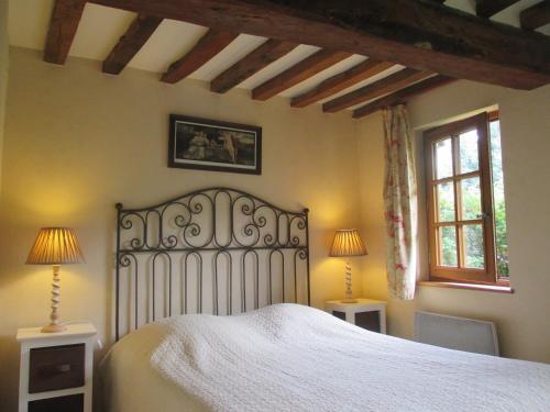 - une chambre avec un lit blanc et 2 fenêtres dans l'établissement Moulin de la Génetée, à Saint-Aubin-sur-Scie