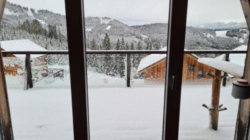 a view of a snow covered yard from a window at Tolles Ferienhaus mit Sauna und Whirlpool in Wolfsberg