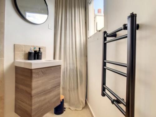 une salle de bain avec un lavabo et un miroir dans l'établissement Appartement Design proche Tour Eiffel avec Balcon, à Paris