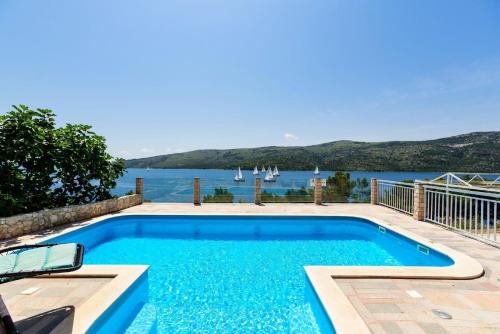 einen Pool mit Blick auf das Wasser in der Unterkunft Seaside Villa Lara - Pinienwald, beheizter Swimming pool in Poljica