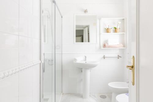 a white bathroom with a sink and a shower at Apartamento independiente en Playa de Regla. in Chipiona