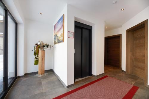 a hallway with two doors and a red rug at Ferienwohnungen Lederstube Seidl in Maria Alm am Steinernen Meer