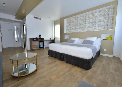 a bedroom with a large bed and a glass table at Rey Don Sancho in Zamora
