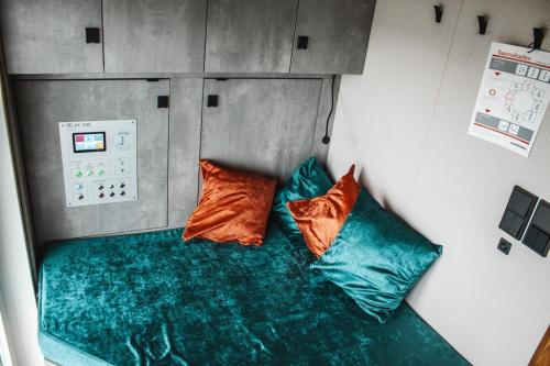 mały pokój z 2 poduszkami siedzącymi na kanapie w obiekcie Hausboot Tegel w mieście Zeuthen