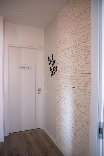 a room with a white door and a brick wall at Flyingaway in Borso del Grappa