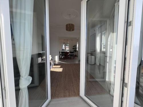 a glass door leading into a room with a dining room at Close to Everything Bright Modern Apartment in Nazaré