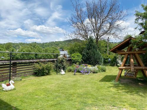 two sheep sitting in the grass in a yard at The Cosy Attic at Casuta Fulgu' in Borşa