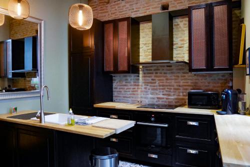 une cuisine avec un évier et un plan de travail dans l'établissement Hiding Place - Loft Toulousain Unique, à Toulouse