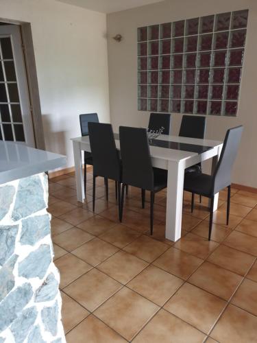 une salle à manger avec une table et des chaises blanches dans l'établissement La Fontaine Amie, à Saint-Rémy