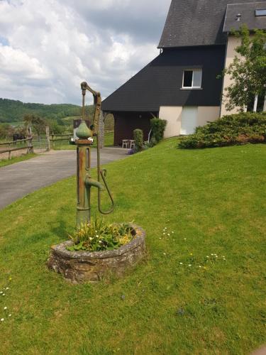 une mangeoire à oiseaux dans l'herbe devant une maison dans l'établissement La Fontaine Amie, à Saint-Rémy