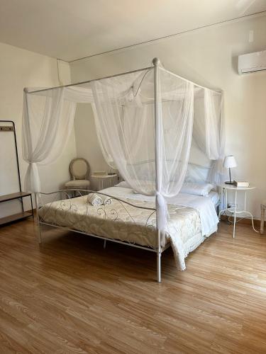a bedroom with a canopy bed and a wooden floor at Doctor House standard, suites & luxury rooms in Enna