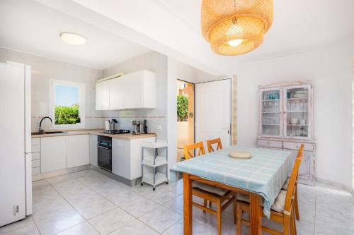 a kitchen and dining room with a table and chairs at Villa Sion in Cala Mendia