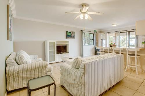 a living room with two couches and a ceiling fan at Garden Route Ilita Lodge in Groot Brak Rivier